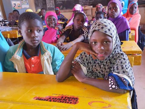 Sakina and friends sitted on the desks they received from World Vision