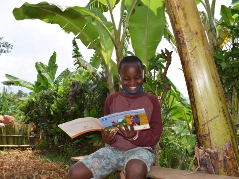 Alpha reading his favorite story book that he got from the reading camp