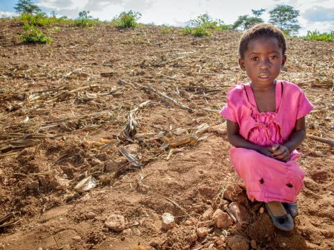  Ruth Makala stands in the gate to her family's garden.