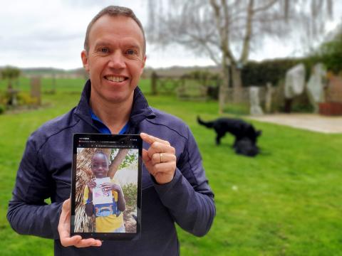 Marcus Frost holds up the picture of the child in Kenya who choose him to be his sponsor