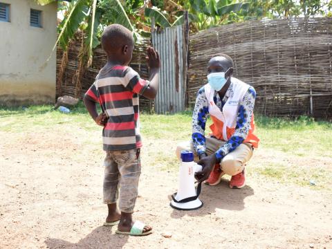 World Vision staff member talks to a child