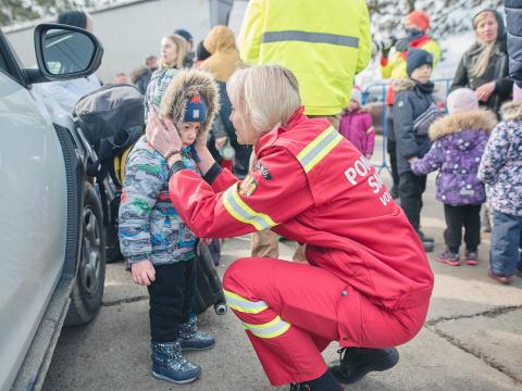 Worker comforts child refugee