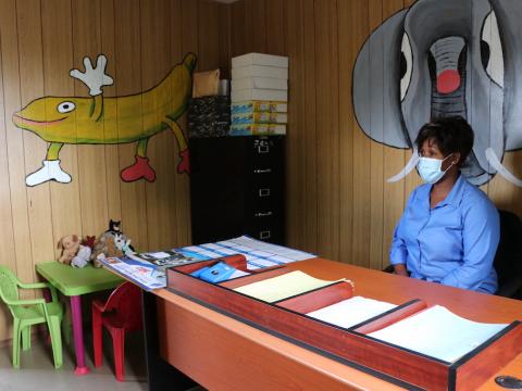 A woman sits at a desk inside the child friendly center