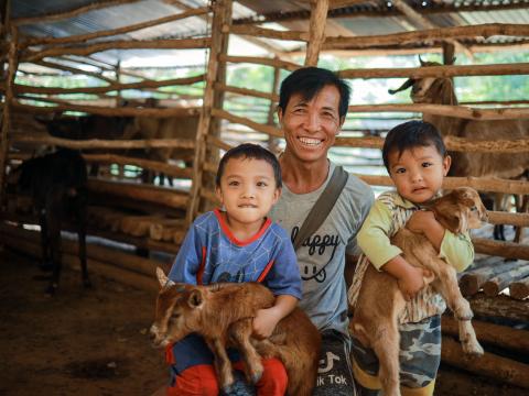 Ngwar Tar enjoys seeing his grandchildren smile while playing with the baby goats in his small goat farm
