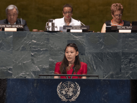 Young girl stands before a council giving a speech