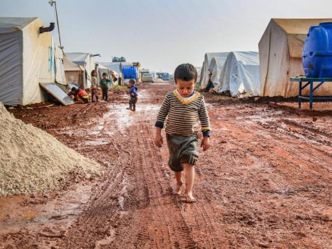 Child walking through refugee camp