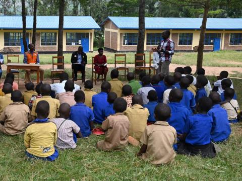 Children who have dropped out of school meeting World Vision staff and partners.