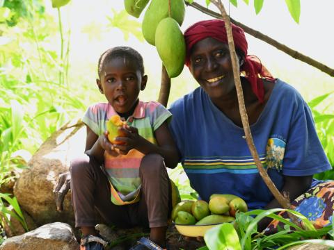 Joyce and her granddaughter Blessing under a mango tree at the family farm in Emsea village, Elgeyo Marakwet County. ©World Vision Photo/ Hellen Owuor