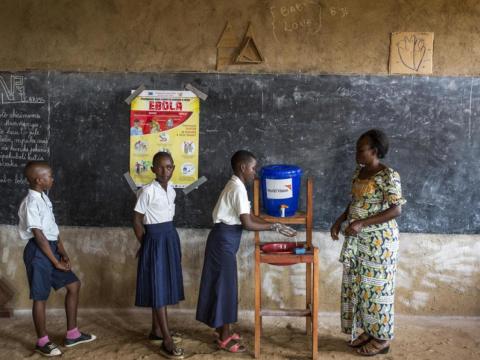 school children stand in line for water