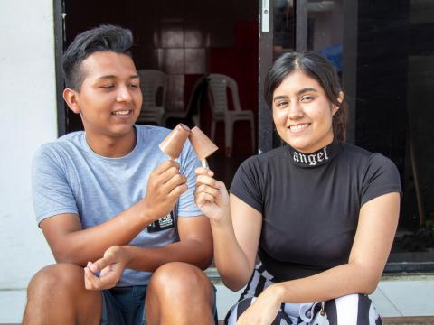 Two young people on a step in Ecuador eating ice cream