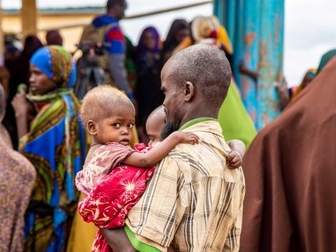 A father comes to a World Vision clinic in Baidoa, southern part of Somalia to receive support for his malnourished kids.