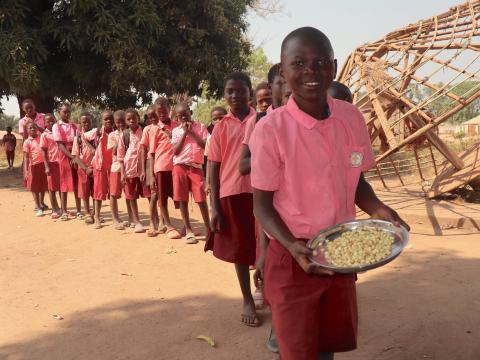 Baraka shows his meal for the day - maize boiled in oil and salt. Meals such as this keep children away from hunger and are able to focus in their classes