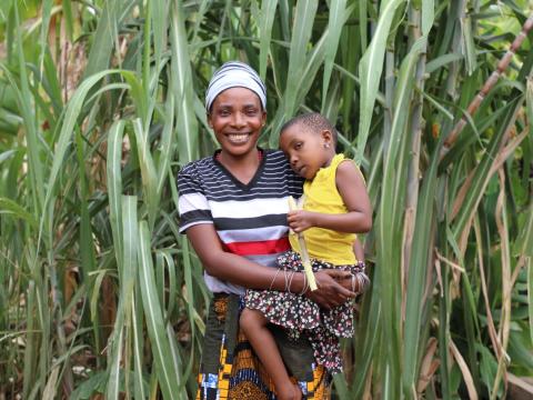 Emeliciana Zimbwe (33) with her daughter Neema (4) in front of their sugar cane field enjoying a moment together (Photo by Olivia Kassano)