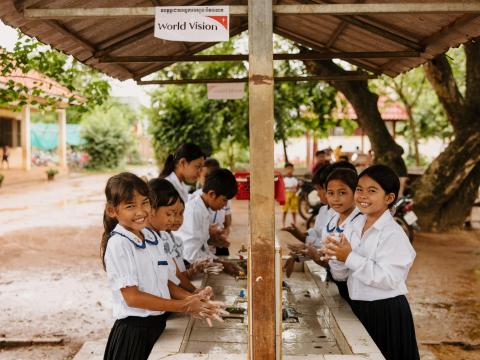 Vanny a child from Cambodia and her friends wash their hands outside their school for the first time, thanks to child sponsorship