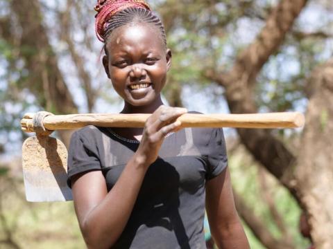 Ruth smiles carrying a stick