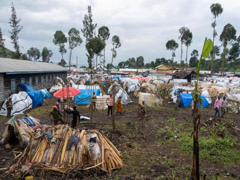 Crowded camp outside a school in DRC with makeshift shelters for displaced people