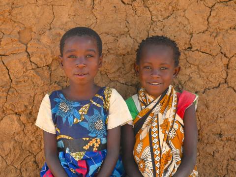 Children sitting against a wall