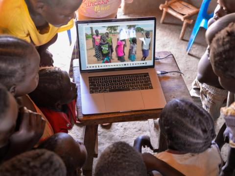 Children watching video of themselves on laptop