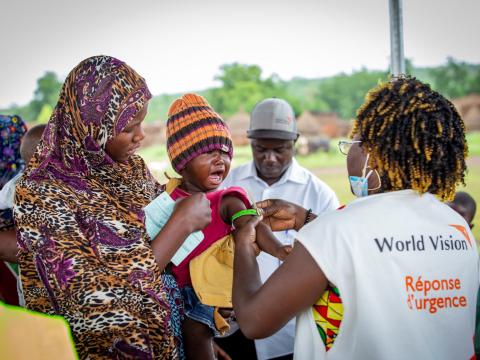 Rachel, the community health worker checks the child's nutritional status