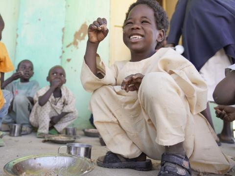 Child enjoying food provided in school through World Vision's school feeding programme