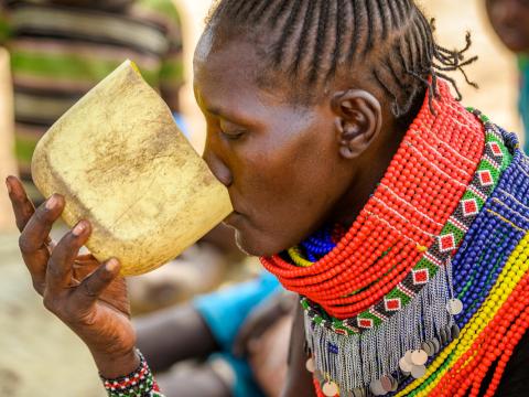 Pauline takes a drink, outside her home in Kalapata AP, Turkana, Kenya