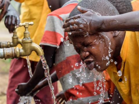 Child washing face from piped water