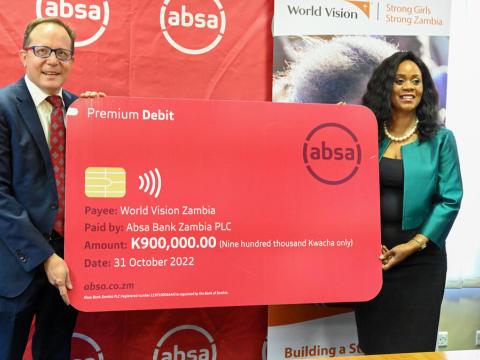 World Vision Zambia National Director John Hasse and Absa Bank PLC Chief Executive Officer Mizinga Melu holding the dummy cheque after signing the MoU