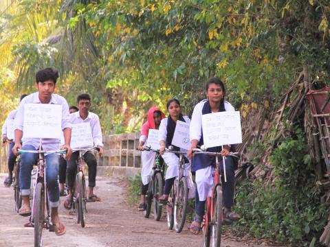 a group of adolescents cycling with advocacy messages