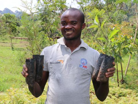 Chance K. holding a seedling in his nursery