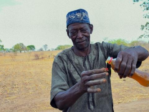 Akugre pouring honey to show it quality