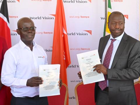 Gilbert Kamanga (left), the World Vision Kenya National Director and Benjamin Cheboi, the Baringo County Governor hold the signed Memorandum of Understanding (MOU) signed between the two organisations. ©World Vision Photo/Sarah Ooko.