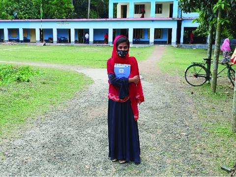 A girl standing outside school building
