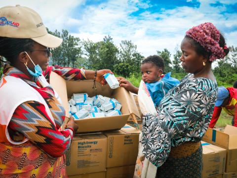 Une femme est sa fille recevant des biscuits à énergétique à Kalehe