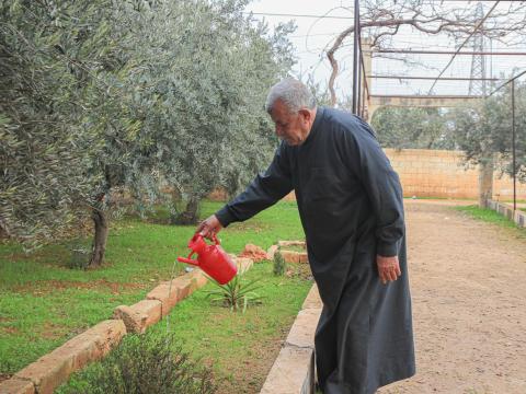 Jassar watering the plants in his garden.