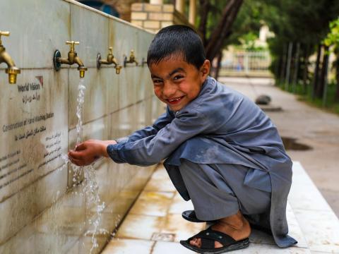 The smiley child in the photo uses a handwashing station built by World Vision under the FCPA project in his school.