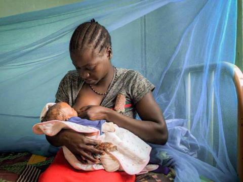 Breastfeeding mum backed by mosquito net