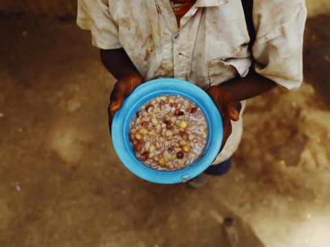 In March 2023 in Myunzi, Tanzania, a school child holds a plate of food.  Because of a prolonged drought causing intense water and food insecurity, feeding programmes are necessary in the area. 