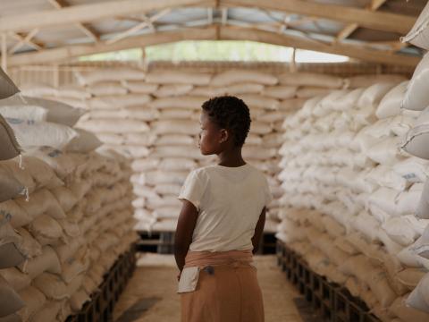 In Kakuma Refugee camp, Turkana, Kenya, Endo, stands in the middle of a warehouse among sacks of food ready to be distributed. A food distribution effort is held by World Vision and its partners.