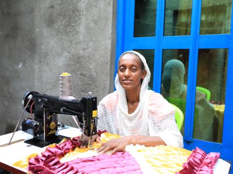 Hiwot making garments with her sewing machine