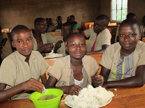 Esther, 13, (with a plate in green) having her lunch at a local school in Nyanza-Lac, Makamba province