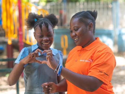 Herncie, a 12-year-old sponsored girl, smiles with Christerlande, a World Vision staffer