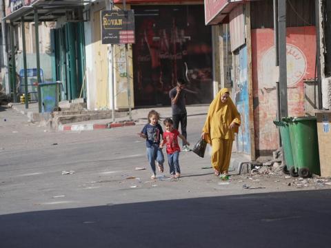 Picture of women in children walking on a deserted street in the West Bank following the crisis. 