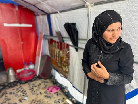 Hayat, from Syria standing in her tent 