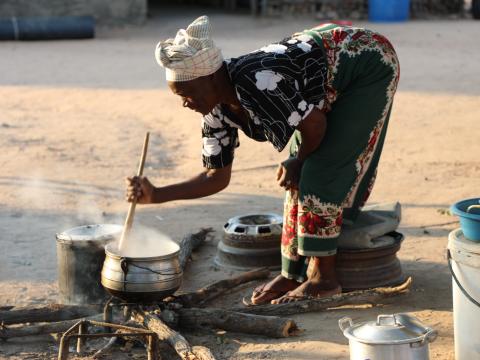 Woman cooking through open fire