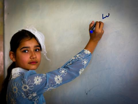 Buthaina writes on the board. Shayan Nuradeen. © World Vision 2024.