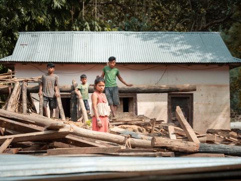 Geeta and her brothers in front of their destroyed house