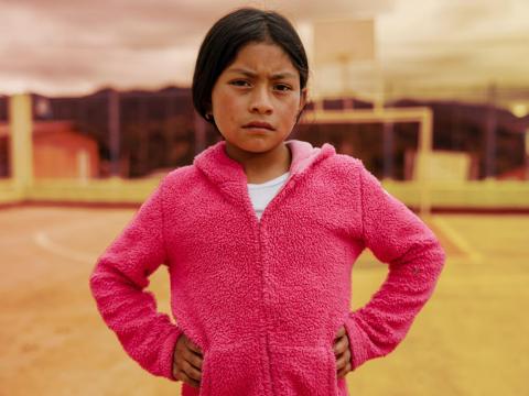 A girl standing straight looking at the camera