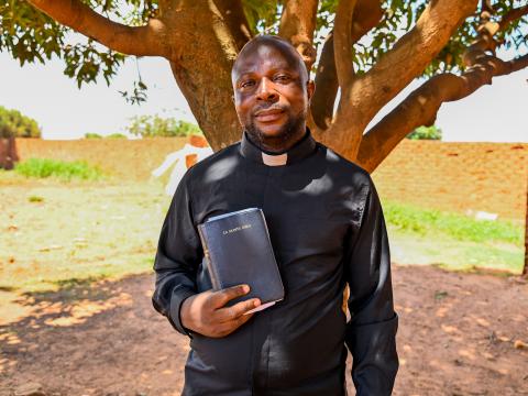Pastor Elysée holding a bible
