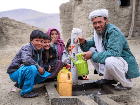 Ali Mohammad and his children share their joy over the newly constructed water network at their home.