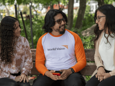 World Vision staff member talks with two young women from the “Youth Without Borders” network, which brings together migrant and host community youth.